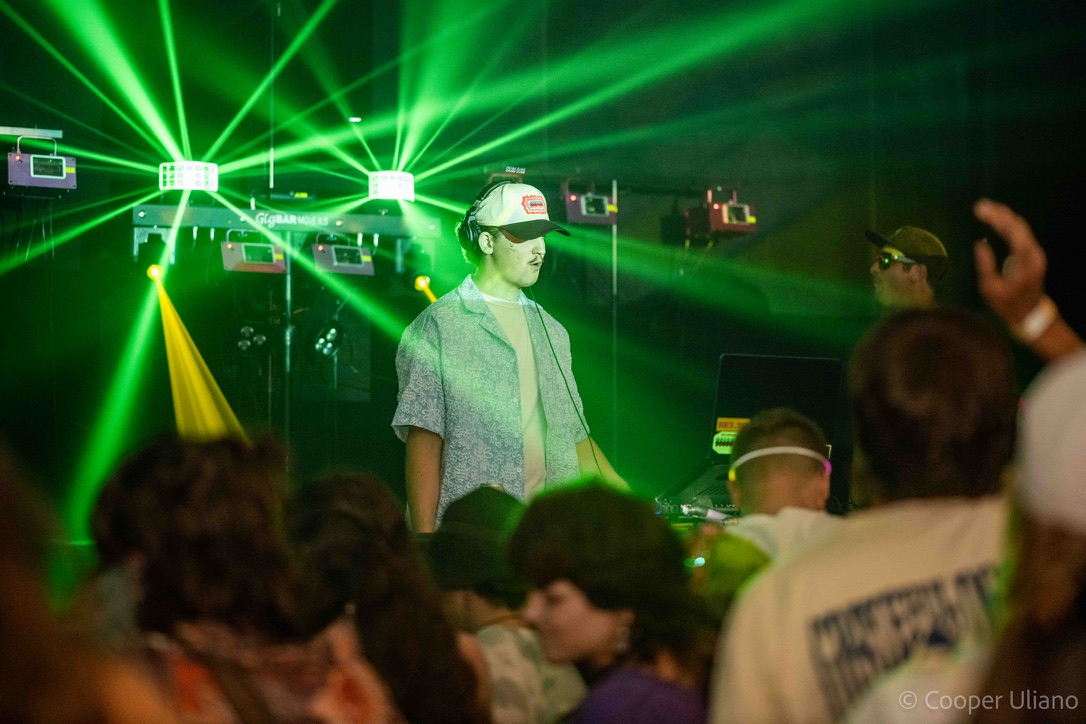 J3RD at the DJ booth with blue and green lasers behind him